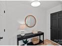 Inviting foyer with a modern round mirror, a stylish console table, and a sleek black front door, creating an elegant entrance at 9027 Twin Trail Dr, Huntersville, NC 28078