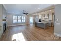 Open-concept living room and kitchen with wood floors, fireplace, large windows, and center island at 1865 Rock Hill Church Rd # 3, Matthews, NC 28104