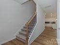 Carpeted staircase with wood and metal railing, leading to an open kitchen at 1150 Red River Dr, Salisbury, NC 28144