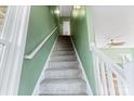 Interior staircase with gray carpeting and sage green walls at 18819 Cloverstone Cir, Cornelius, NC 28031