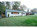 Newly renovated ranch home with a modern facade and landscaped lawn at 4039 Uppergate Ln, Charlotte, NC 28215