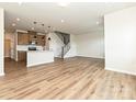 Open-concept living space with hardwood floors and a modern kitchen featuring stainless steel appliances at 5676 Clear Creek Ln, Charlotte, NC 28215