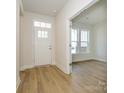 Bright entryway with hardwood floors, white door and trim, and a view into the adjacent room at 7169 Chamberlain Dr, Harrisburg, NC 28075