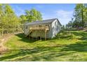 Rear exterior showing a deck and walkout basement on a sloped lot bordered by mature trees at 3146 Captains Cove Ln, Lincolnton, NC 28092