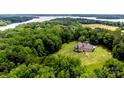 Aerial view of a secluded home surrounded by lush greenery and a sparkling lake at 3678 Rankin Rd, Concord, NC 28027