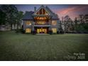 Expansive backyard view of a brick home with a large balcony overlooking the lush lawn at 3678 Rankin Rd, Concord, NC 28027
