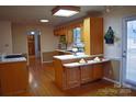 Eat-in kitchen featuring wood cabinets, tile countertops, and an outside access door at 115 Turner St, Lincolnton, NC 28092