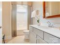 Well-lit bathroom with a single vanity, framed mirror, tiled floors, and a shower with a shower curtain at 3848 Zemosa Nw Ln, Concord, NC 28027