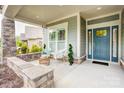 Inviting covered porch with stone accents and ample seating, perfect for relaxing and enjoying the outdoors at 3848 Zemosa Nw Ln, Concord, NC 28027