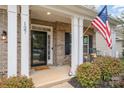 Brick front porch with white columns, American flag, and potted plants at 127 Avalon Reserve Dr, Mooresville, NC 28115