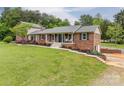 Inviting brick home with well-kept lawn, charming front porch, and landscaped garden beds at 3092 Lee Lawing Rd, Lincolnton, NC 28092