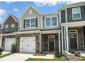 Attractive townhome featuring a stone facade, one-car garage, and manicured lawn at 6259 Tea Olive Dr # 178, Harrisburg, NC 28075