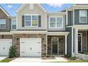 Stylish townhome with mixed materials, including stone, shingles, and siding with an available sign at 6259 Tea Olive Dr # 178, Harrisburg, NC 28075