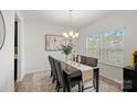 Elegant dining room with chandelier, window with blinds, and seating for six at 7618 Fenn Way, Indian Land, SC 29707