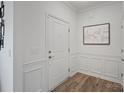 Inviting foyer with decorative wall panels, wood-look flooring, and a front door at 7618 Fenn Way, Indian Land, SC 29707