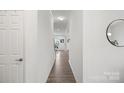 Bright hallway with wood-look flooring, white walls, and a view towards the living areas at 7618 Fenn Way, Indian Land, SC 29707