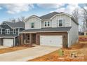 Charming two-story home with an attached two-car garage and beautifully manicured front lawn at 118 Satchel Ct, Troutman, NC 28115