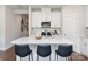 Bright kitchen featuring white cabinets, stainless steel appliances, and a large quartz island with stylish seating at 122 Satchel Ct, Troutman, NC 28115