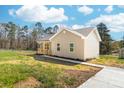 Exterior of a charming beige home featuring a covered front porch with wooden railings, with a freshly poured concrete driveway at 501 Ed Wilson Rd, Bessemer City, NC 28016