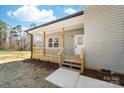 Close-up of a charming front porch, showcasing wooden railings, steps, and the home's address, 501 at 501 Ed Wilson Rd, Bessemer City, NC 28016