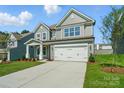 Two-story home with gray siding, white trim, and an attached two-car garage at 5112 Heathland Dr # 75, Charlotte, NC 28215