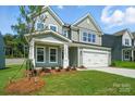 Traditional two-story home with a manicured front lawn and a two-car garage at 5112 Heathland Dr # 75, Charlotte, NC 28215