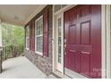 Inviting entryway with stone accents, red door, and decorative shutters create curb appeal at 8905 Valleymoon Ln, Charlotte, NC 28214