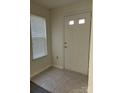 Bright entryway featuring neutral tile flooring, a white front door, and natural light from the window at 9013 Trellis Pointe Blvd, Charlotte, NC 28227