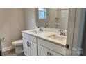 Double vanity bathroom with white cabinets and a large mirror at 102 Obadiah Ct, Troutman, NC 28115