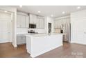 Modern kitchen features white cabinets, stainless steel appliances, and a large center island at 103 Obadiah Ct, Mooresville, NC 28115