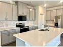 Modern kitchen with gray cabinets, quartz countertops, and stainless steel appliances at 103 Obadiah Ct, Mooresville, NC 28115