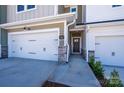 New townhome featuring a two-car garage and covered entry with stone accents at 149 Halite Ln, Waxhaw, NC 28173