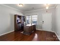 Bright home office with a large wooden desk, hardwood floors, and a built-in bookcase at 8007 April Ln, Matthews, NC 28104