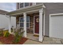Inviting front porch with rocking chairs and a decorative wreath on the front door at 318 Kingsford Dr, Stanley, NC 28164