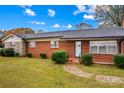 Close-up of a brick home featuring a well-manicured lawn and an inviting front entrance with shrubbery at 4501 Taylorsville Hwy, Statesville, NC 28625