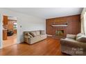Spacious living room with hardwood floors, brick fireplace and neutral-toned furniture at 4501 Taylorsville Hwy, Statesville, NC 28625