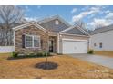 Beautiful single-Gathering home with stone accents, well-kept lawn, and attached garage at 654 Saddlebred Ln, Locust, NC 28097