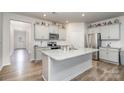 Well-lit kitchen with gray cabinets, stainless appliances, granite countertops, and a spacious island at 654 Saddlebred Ln, Locust, NC 28097