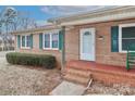 Brick front entrance with green shutters and rocking chair at 105 Kiser Ln, Statesville, NC 28677