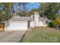 Ranch home with a three-car garage and landscaped lawn at 11800 Five Cedars Rd, Charlotte, NC 28226