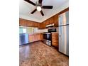 Well-lit kitchen with stainless steel appliances, wood cabinets, and a ceiling fan at 7324 Pebblestone Dr # F, Charlotte, NC 28212