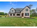 Beautiful two-story brick home features a manicured lawn and an elegant arched doorway at 407 Crepe Myrtle Ln, Weddington, NC 28104