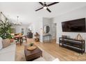 Open concept living room showcasing modern decor, an adjacent dining area, and wood floors at 8225 Ballymore Ct, Huntersville, NC 28078