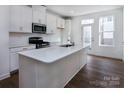 Modern kitchen with white cabinets, island, and stainless steel appliances at 2212 Noble Townes Way, Charlotte, NC 28262