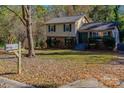 House with a brick base and light yellow siding, surrounded by trees at 3316 Valley Grove Rd, Charlotte, NC 28227