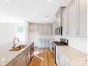 Modern kitchen with gray cabinets, granite countertops, and stainless steel appliances at 9924 Manor Vista Trl, Kannapolis, NC 28027