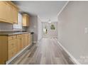 Open kitchen with natural wood cabinets, views to the back, and access to bonus room at 27 Sw Barbee Rd, Concord, NC 28027
