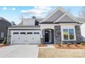 Charming single-Gathering home featuring stone accents, a two-car garage, and a well-manicured lawn at 4021 Grace Pointe Dr # 104, Wesley Chapel, NC 28079