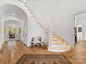 Elegant foyer features a curved staircase, hardwood floors, and a bright, open space at 6040 Oxfordshire Rd, Waxhaw, NC 28173