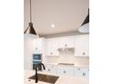 Modern kitchen featuring white cabinets, stainless steel appliances, and tiled backsplash at 7928 Cedarsmith Ct, Charlotte, NC 28217